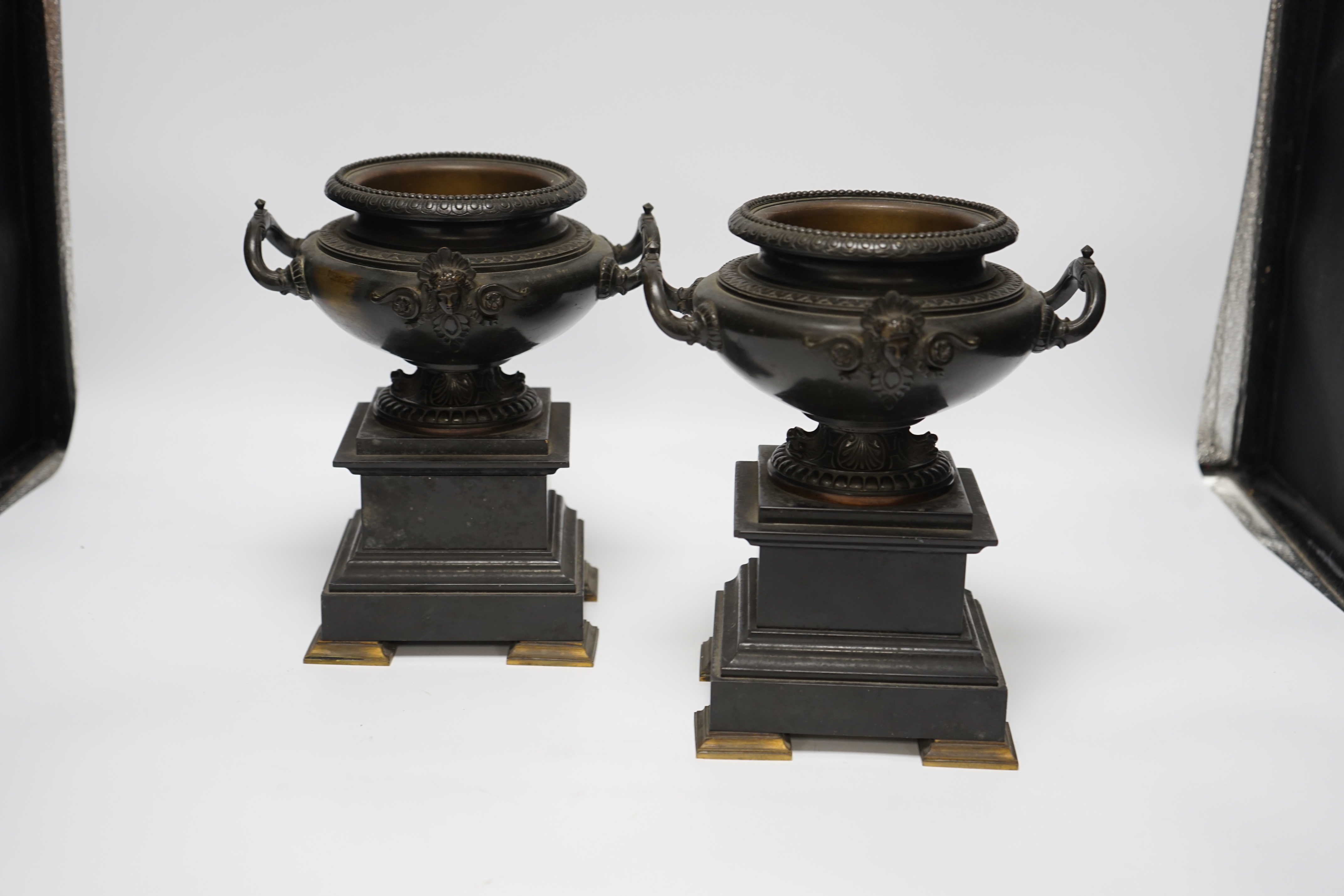 A pair of 19th century bronze urns on slate pedestals, 21.5cm high